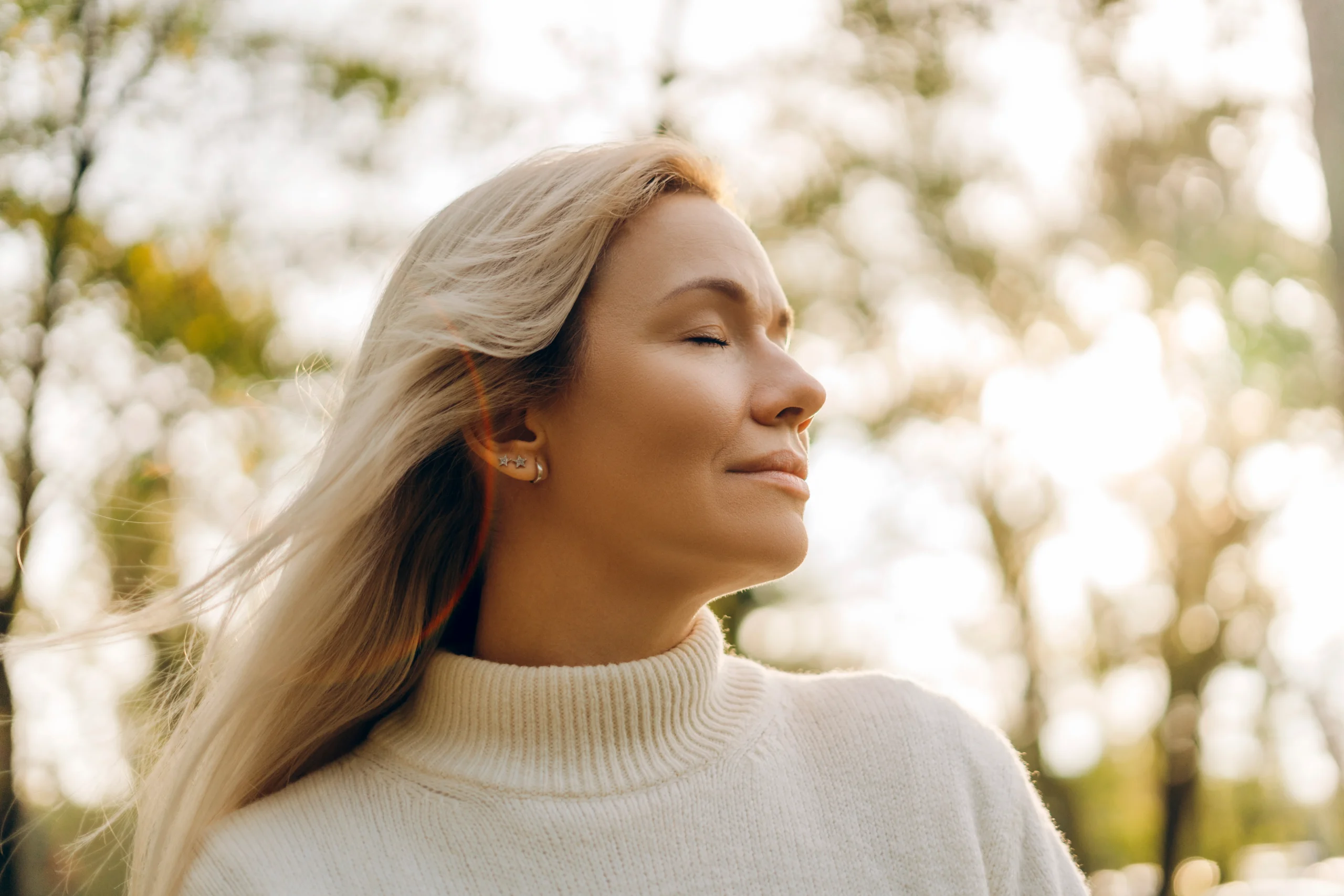Woman with closed eyes resting in natural light.